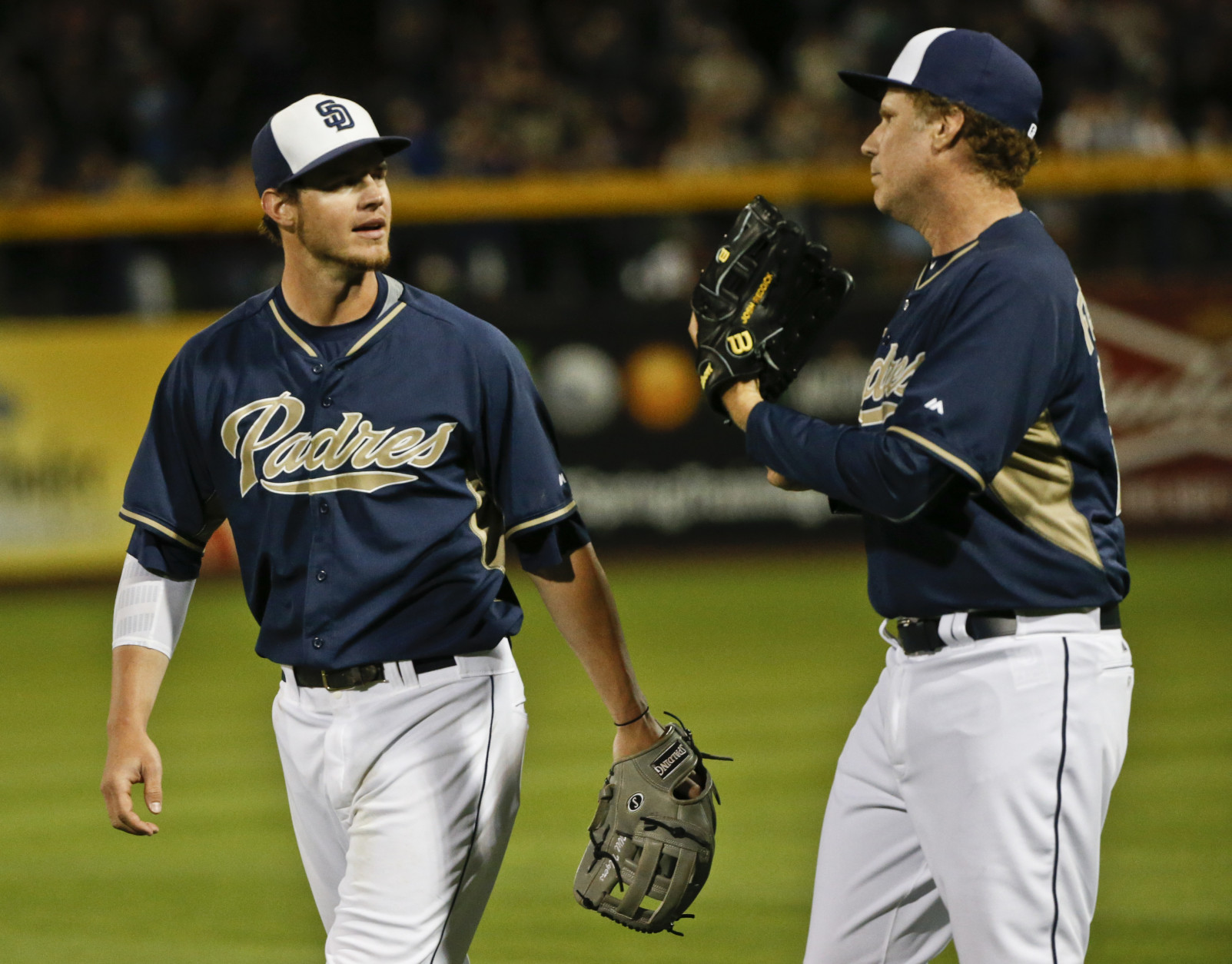 Actor Will Ferrell talks with San Diego Padres center fielder Wil Myers as the pair come off the field following an inning in which Ferrell played right field for the Padres in a spring training baseball game against the Los Angeles Dodgers Thursday, March 12, 2015, in Peoria, Ariz.  (AP Photo/Lenny Ignelzi)