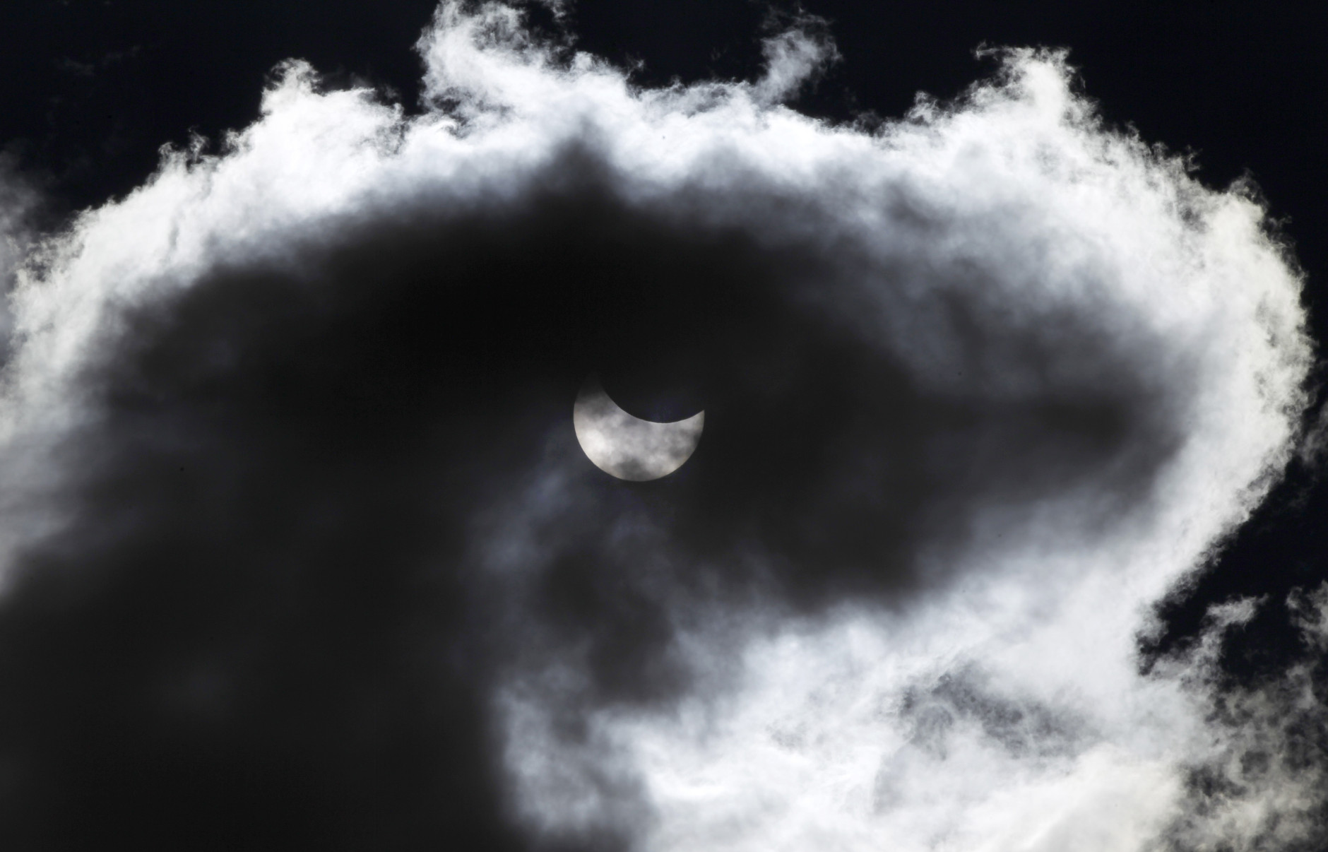 The moon starts to block the sun during a solar eclipse seen through a cloud, in Skopje, Macedonia, Friday, March 20, 2015. An eclipse, a rare solar event, is darkening parts of Europe on Friday in the last total solar eclipse in Europe for over a decade (AP Photo/Boris Grdanoski)