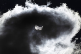 The moon starts to block the sun during a solar eclipse seen through a cloud, in Skopje, Macedonia, Friday, March 20, 2015. An eclipse, a rare solar event, is darkening parts of Europe on Friday in the last total solar eclipse in Europe for over a decade (AP Photo/Boris Grdanoski)