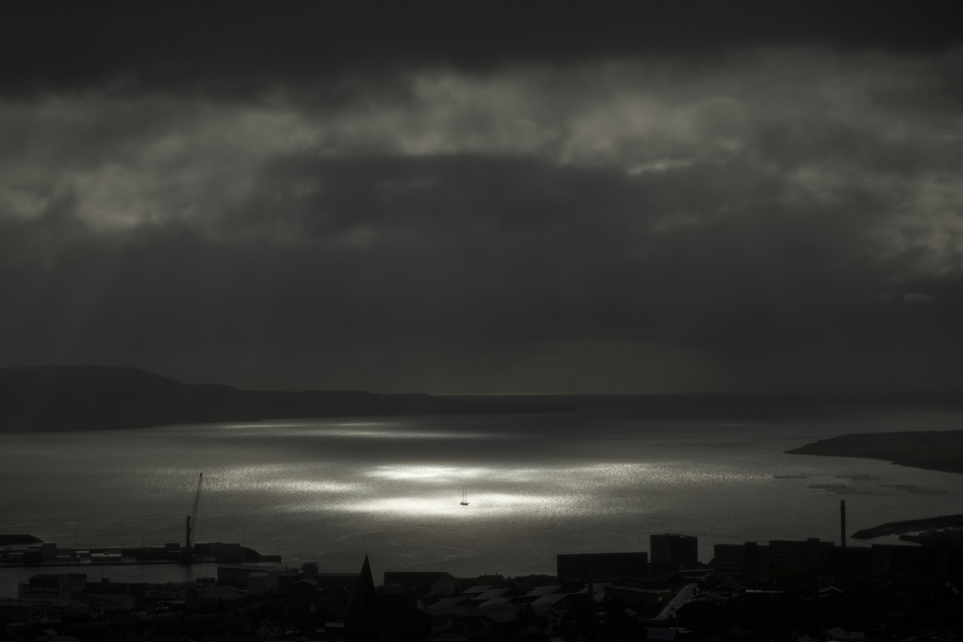 A spot of sunlight breaks through the clouds and shines on a vessel on the sea during the partial phase of a solar eclipse before totality as seen from a hill beside a hotel on the edge of the city overlooking Torshavn, the capital of the Faeroe Islands, Friday, March 20, 2015. A blanket of clouds in the Faeroe Islands blocked thousands of people there from experiencing the full effect of the total eclipse. The clouds then cleared after totality.  (AP Photo/Matt Dunham)