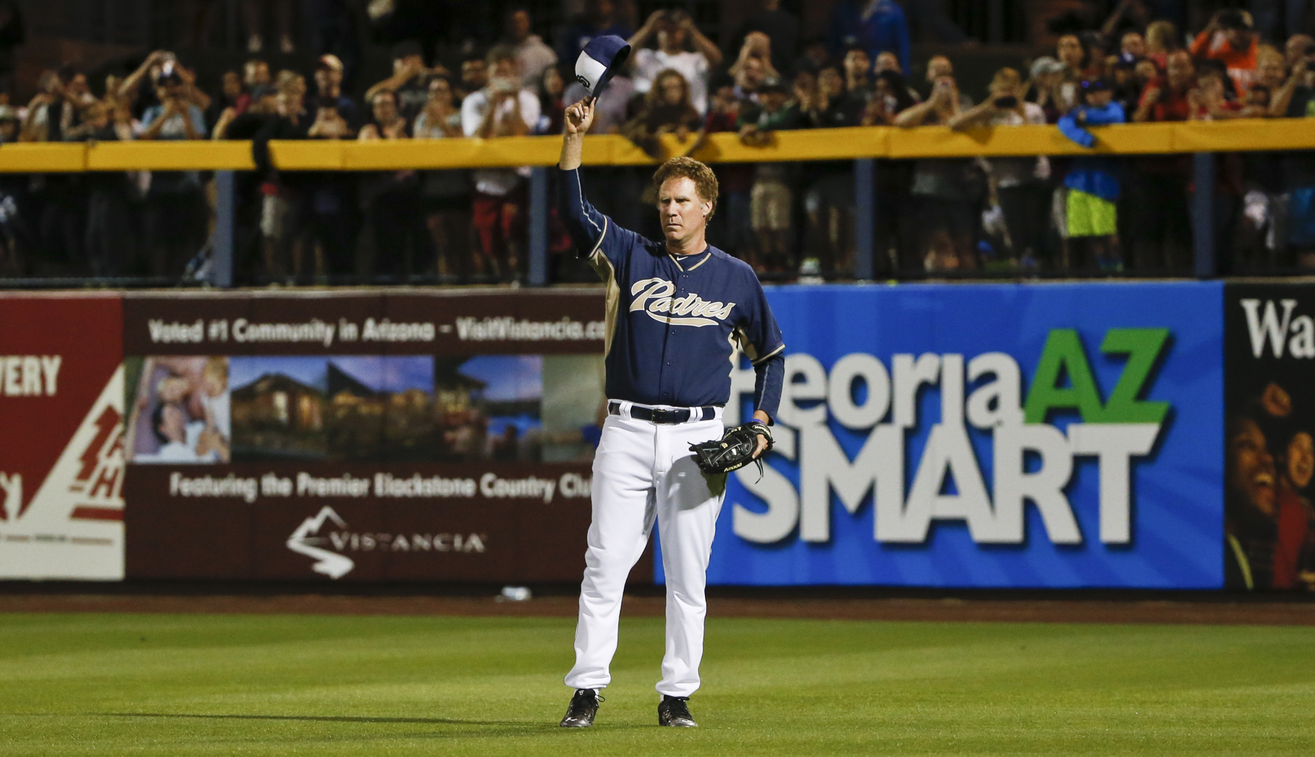 Actor Will Ferrell waves to the crowd after taking his position in right field for the San Diego Padres during a spring training baseball game between the Padres and the Los Angeles Dodgers on Thursday, March 12, 2015, in Peoria, Ariz.  (AP Photo/Lenny Ignelzi)