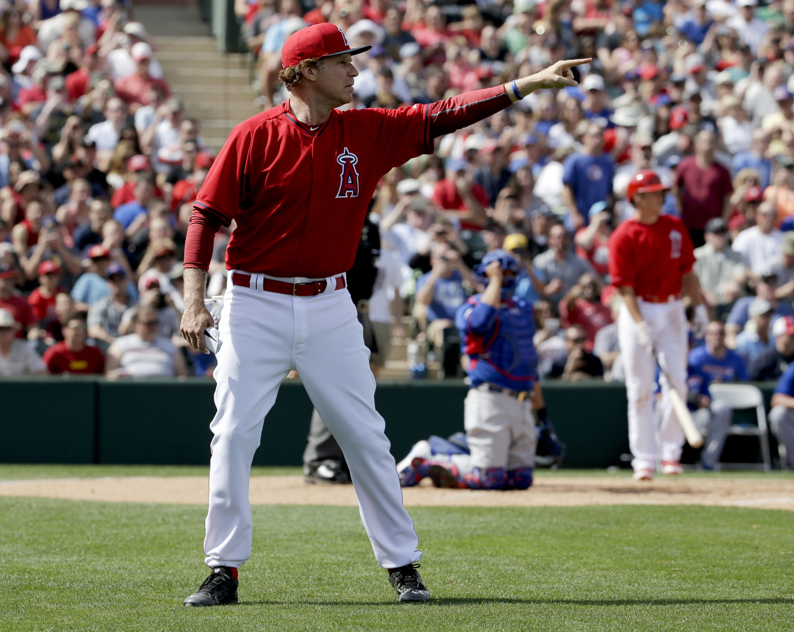 Actor Will Ferrell dressed as a Los Angeles Angels player yells to ball players during a spring training baseball exhibition game against the Chicago Cubs in Tempe, Ariz., on Thursday, March 12, 2015. The comedian plans to play every position while making appearances at five Arizona spring training games on Thursday. (AP Photo/Chris Carlson)