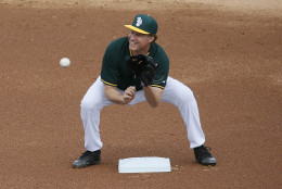 Actor Will Ferrell warms up at shortstop for the Oakland Athletics prior to the first inning of a spring training baseball game against the Seattle Mariners, Thursday, March 12, 2015, in Mesa, Ariz. Telling everyone "I'm a five-tool guy," Ferrell was off on his barnstorming tour Thursday through five Arizona spring training games.  (AP Photo/Matt York)
