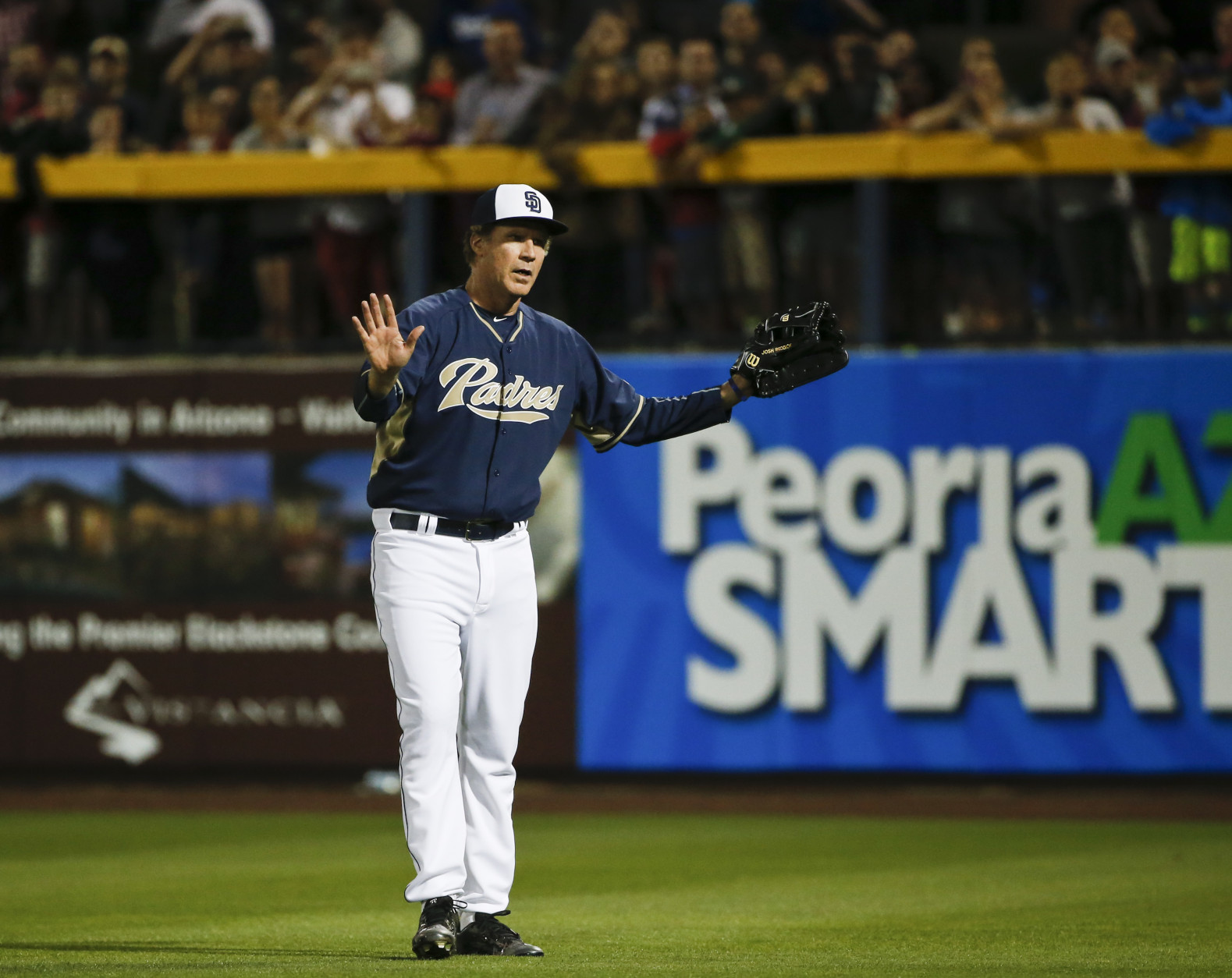 Actor Will Ferrell responds to the crowd's cheers while playing right field for the San Diego Padres during a spring training baseball game between the Padres and the Los Angeles Dodgers Thursday, March 12, 2015, in Peoria, Ariz.  (AP Photo/Lenny Ignelzi)