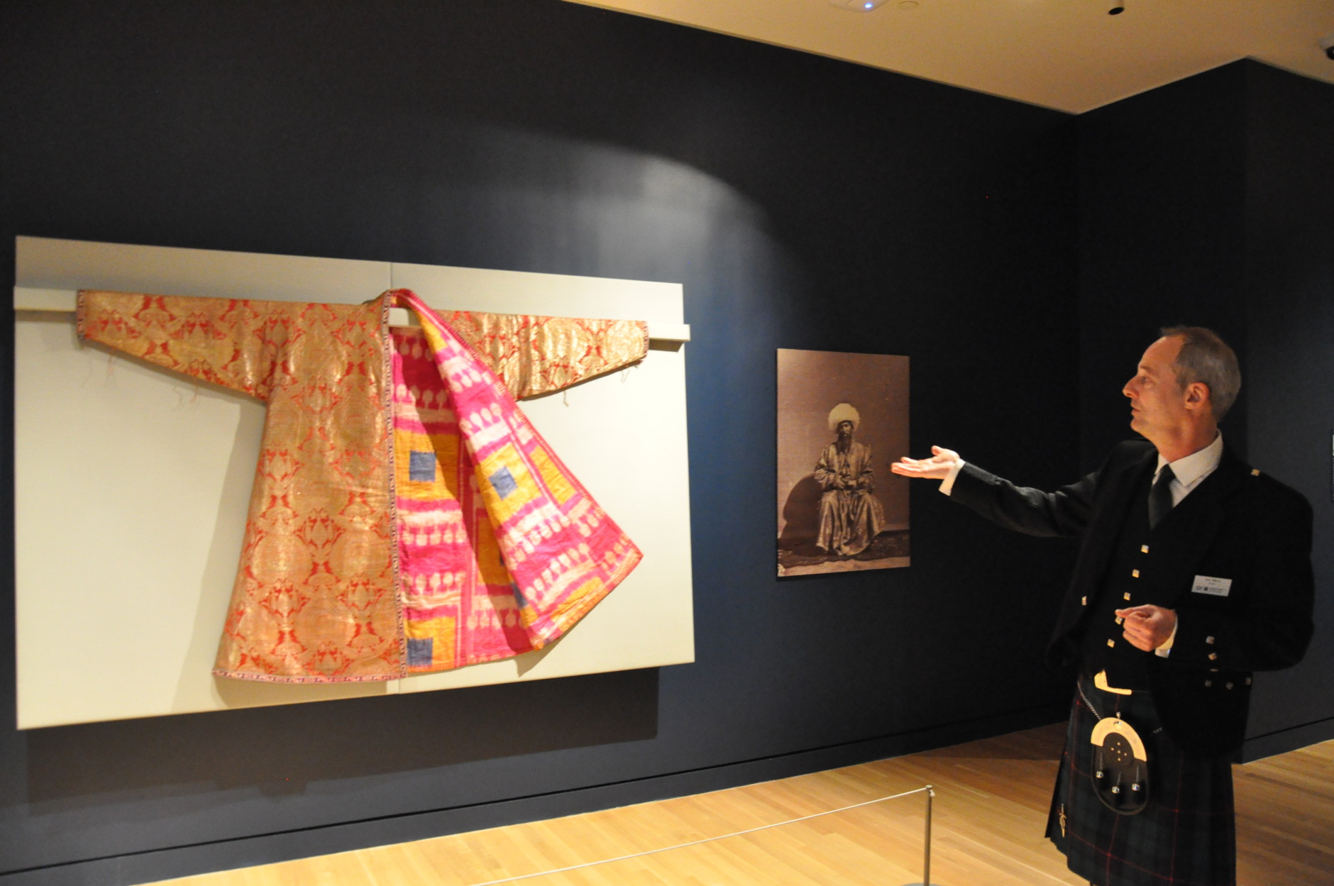 Curator Lee Talbot leads a small tour through the exhibit “Unraveling Identity: Our Textiles, Our Stories,” at The Textile Museum.  Talbot explains how everything from uniforms, to rugs, costumes and wedding dresses demonstrate power, status and personal identity. 