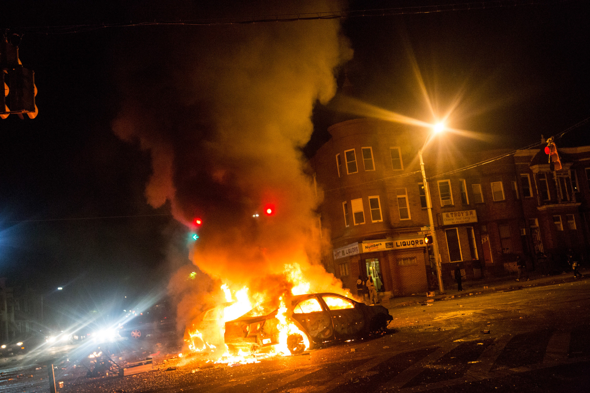 BALTIMORE, MD - APRIL 27:  Two cars burn in the middle of an intersection at New Shiloh Baptist Church on April 27, 2015 in Baltimore, Maryland. Riots have erupted in Baltimore following the funeral service for Freddie Gray, who died last week while in Baltimore Police custody.  (Photo by Andrew Burton/Getty Images)