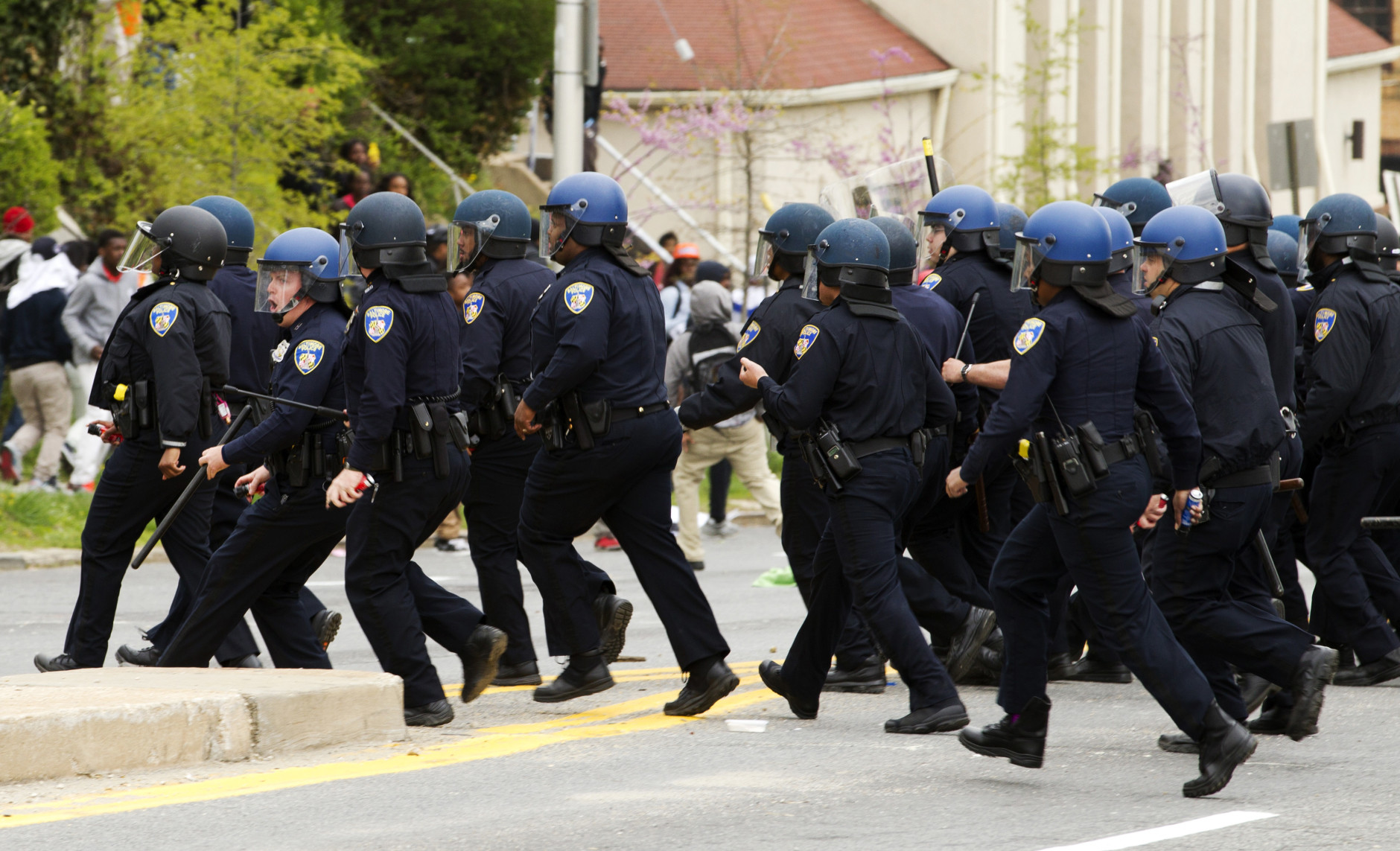Baltimore police officers push back demonstrators who are throwing rocks at the police, after the funeral of Freddie Gray, Monday, April 27, 2015, at New Shiloh Baptist Church in Baltimore. Gray died from spinal injuries about a week after he was arrested and transported in a Baltimore Police Department van.  (AP Photo/Jose Luis Magana)