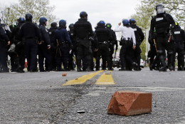 A brick sits on a street as police standby, Monday, April 27, 2015, during a skirmish with demonstrators after the funeral of Freddie Gray in Baltimore. Gray died from spinal injuries about a week after he was arrested and transported in a Baltimore Police Department van. (AP Photo/Patrick Semansky)