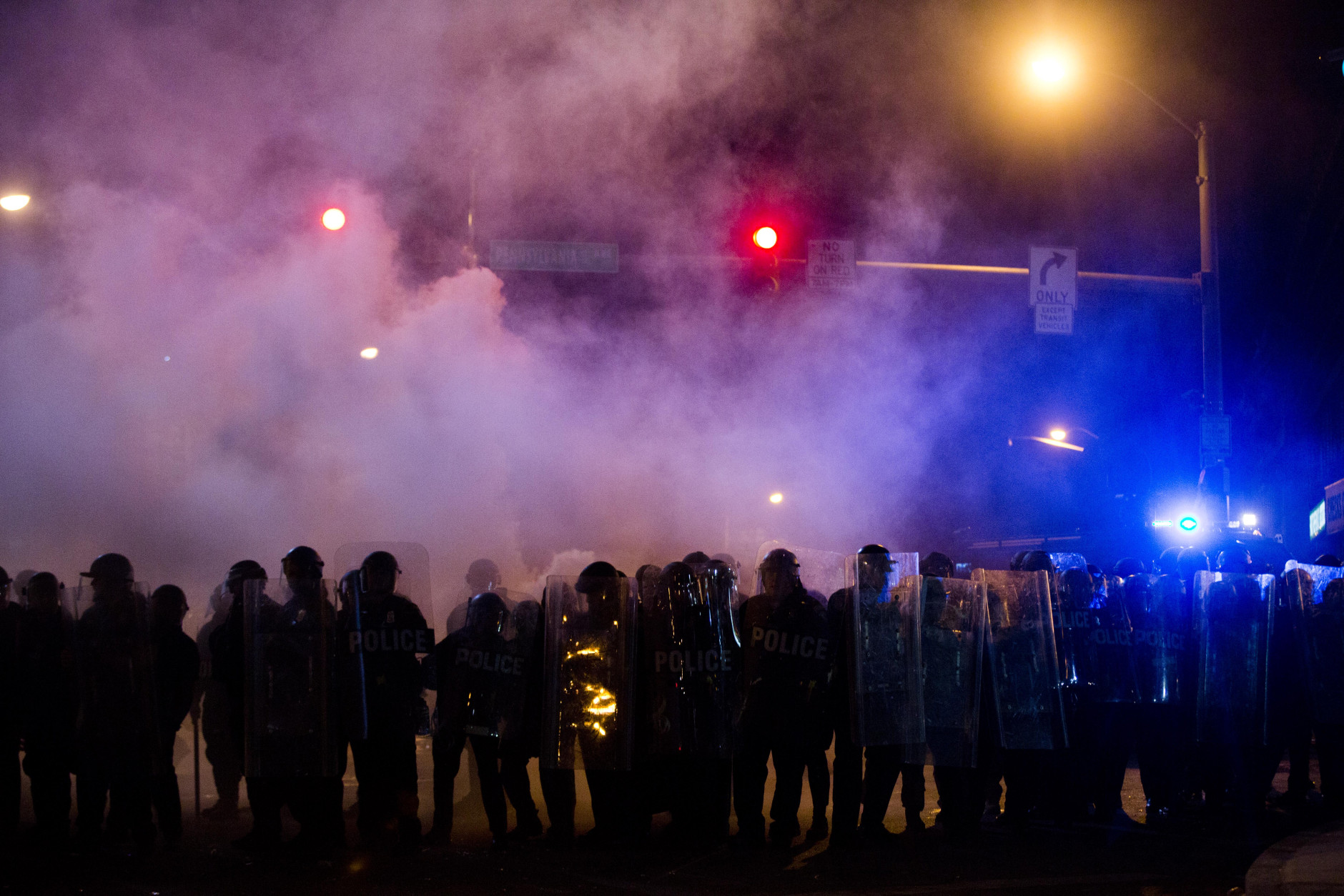 Police advance through a cloud of tear gas as they enforce curfew, Tuesday, April 28, 2015, in Baltimore, a day after unrest that occurred following Freddie Gray's funeral. (AP Photo/Matt Rourke)