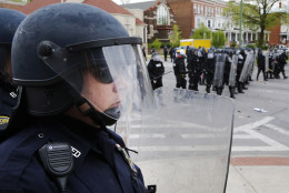 Police stand in formation in response to demonstrators who were throwing objects at police, Monday, April 27, 2015, after the funeral of Freddie Gray in Baltimore. Gray died from spinal injuries about a week after he was arrested and transported in a Baltimore Police Department van. (AP Photo/Patrick Semansky)
