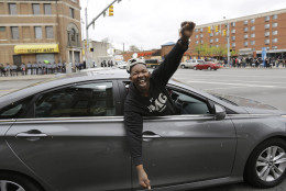 A passing motorist celebrates in the intersection where some of Monday's riots occurred on Friday, May 1, 2015, after State's Attorney Marilyn J. Mosby announced criminal charges against all six officers suspended after Freddie Gray suffered a fatal spinal injury while in police custody in Baltimore.  Mosby announced the stiffest charge, second-degree depraved heart murder, against the driver of the police van. Other officers faced charges of involuntary manslaughter, assault and illegal arrest.  (AP Photo/David Goldman)
