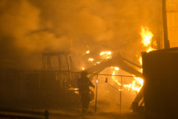 Firefighters battle a blaze, Monday, April 27, 2015, after rioters plunged part of Baltimore into chaos, torching a pharmacy, setting police cars ablaze and throwing bricks at officers. (AP Photo/Matt Rourke)