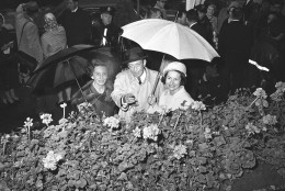 Lady Bird Johnson, wife of Pres. Johnson, uses an umbrella to keep dry as she and New York's Mayor Robert F. Wagner, center, with Anna Rosenberg Hoffman, left, co-chairman of the city's "Salute to Season" program, inspect a flower display at the Plaza Hotel in New York, May 7, 1965.  The nation's first lady called upon New Yorkers to use green thumbs in beautifying the city's streets.  (AP Photo/John Lent)
