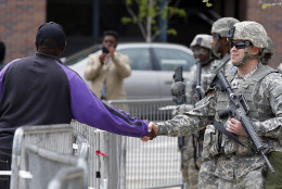 A man shakes hands with a National Guard soldier outside City Hall, Friday, May 1, 2015 in Baltimore. State's Attorney Marilyn J. Mosby announced criminal charges Friday,  against all six officers suspended after Freddie Gray suffered a fatal spinal injury in police custody. Mosby announced the stiffest charge, second-degree depraved heart murder,  against the driver of the police van. Other officers faced charges of involuntary manslaughter, assault and illegal arrest.  (AP Photo/Alex Brandon)
