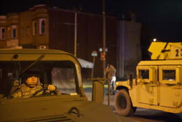 Members of the National Guard pass through the area where Monday's riots occurred following the funeral for Freddie Gray, after a 10 p.m. curfew went into effect, Tuesday, April 28, 2015, in Baltimore. (AP Photo/David Goldman)