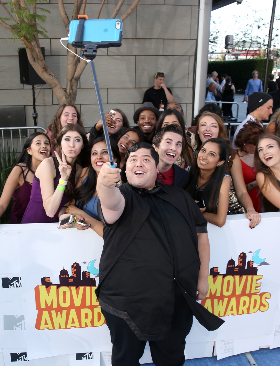 Harvey Guillen takes a selfie with fans as he arrives at the MTV Movie Awards at the Nokia Theatre on Sunday, April 12, 2015, in Los Angeles. (Photo by Matt Sayles/Invision/AP)