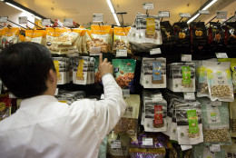 In this Thursday, April 9, 2015 photo, a worker stocks up on almonds packaged as originating from the United States at a supermarket in Beijing.  Last year almond orchards consumed more of Californias vanishing water than the indoor use of all 39 million California residents combined. As California enters its fourth year of drought, and imposes the first mandatory statewide water cutbacks on cities and towns, the $6.5 billion almond crop is helping drive a sharp debate about water use, agricultural interests and how both affect the states giant economy. (AP Photo/Ng Han Guan)