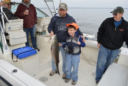 On the first day of rockfish season in 2014 a proud young angler displays his catch. New size restrictions in 2015 are an attempt to prevent over-fishing by decreasing total harvest by 25 percent. (Courtesy Candy Thomson/Maryland DNR) 