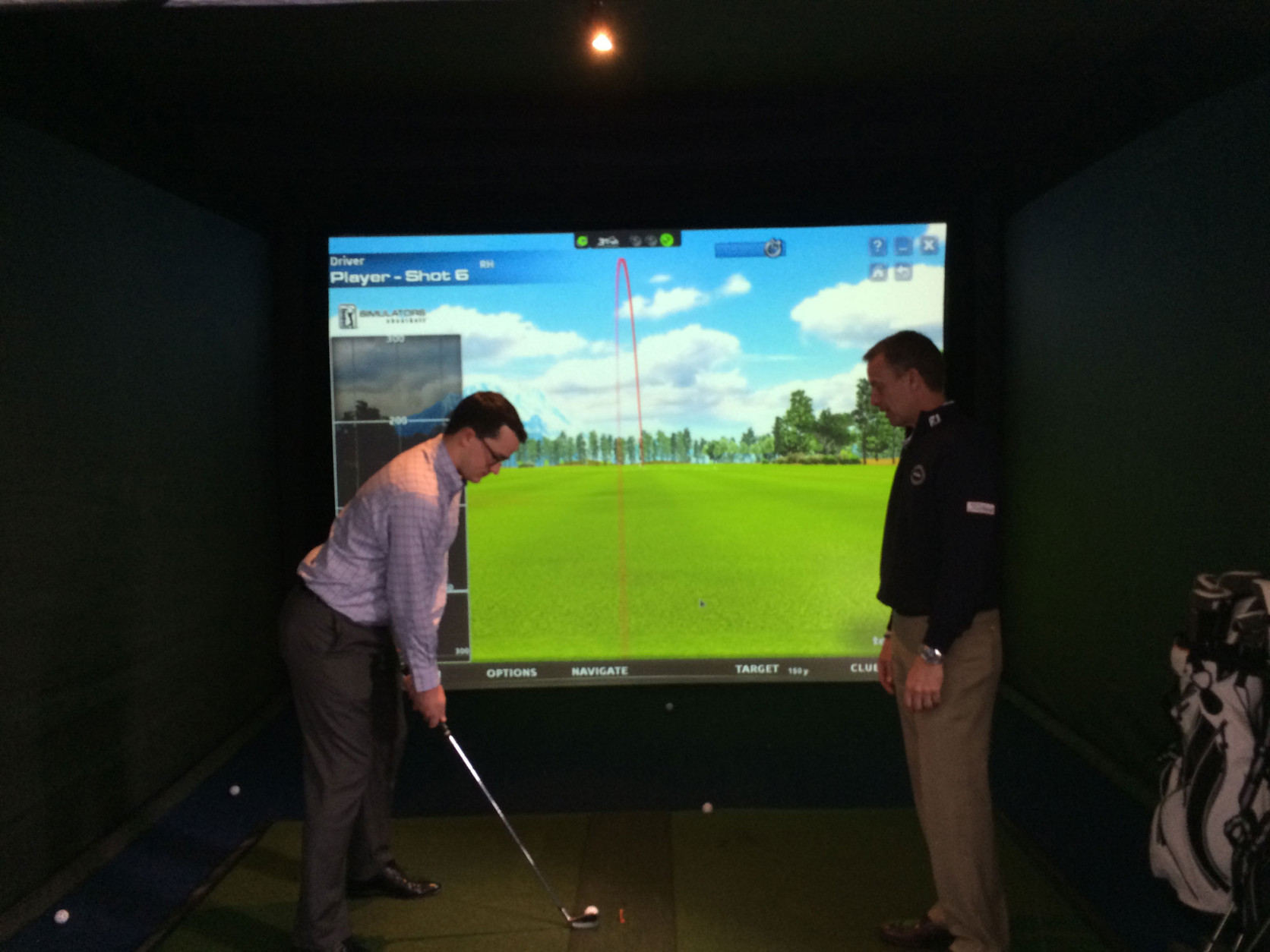 Golf professionals gave tips as players practiced shots on a simulator. (WTOP/Noah Frank)