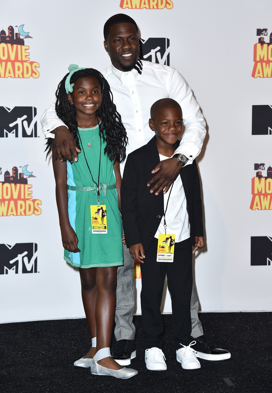 Kevin Hart, winner of the comedic genius award, poses in the press room with his kids Heaven Hart, left, and Hendrix Hart, right, at the MTV Movie Awards at the Nokia Theatre on Sunday, April 12, 2015, in Los Angeles. (Photo by Jordan Strauss/Invision/AP)