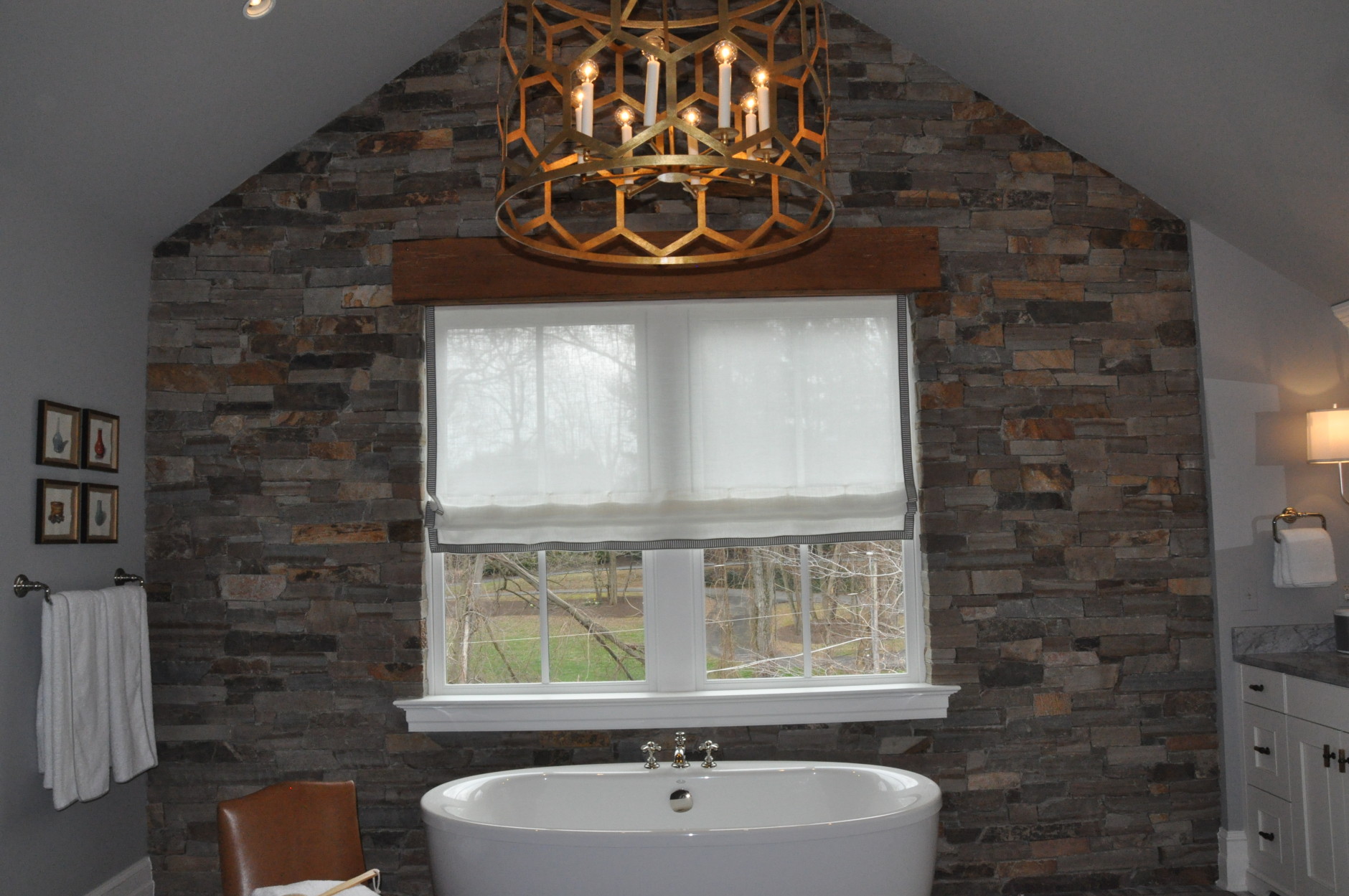 The main point of focus in the master bathroom, also designed by Christopher Patrick, is a floor-to-ceiling stone wall and simple oval-shaped tub. (WTOP/Rachel Nania) 