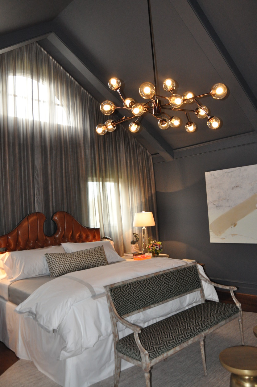 The master bedroom, designed by Christopher Patrick, is both dramatic and calming/cozy at the same time. Patrick used a mix of slate gray, cognac leather and emerald green for the room's color palette. (WTOP/Rachel Nania) 
