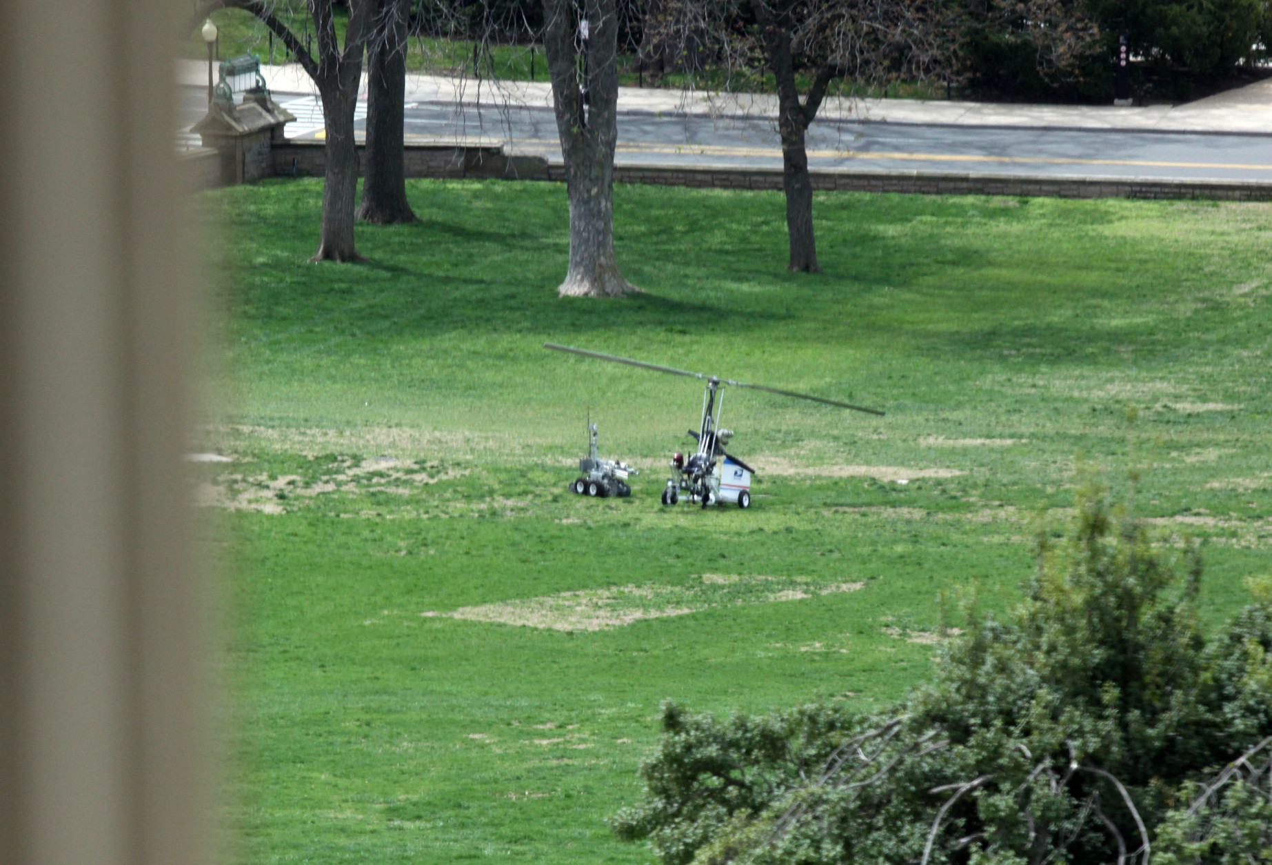 A police device rolls toward a copter device, right, that landed on the West Front of the Capitol in Washington, Wednesday, April 15, 2015. A small one-person helicopter has landed on the West Lawn of the U.S. Capitol, prompting a temporary lockdown of the Capitol Visitor's Center. Capitol Police approached the aircraft shortly after it touched down and took its pilot into custody. (AP Photo/Lauren Victoria Burke)