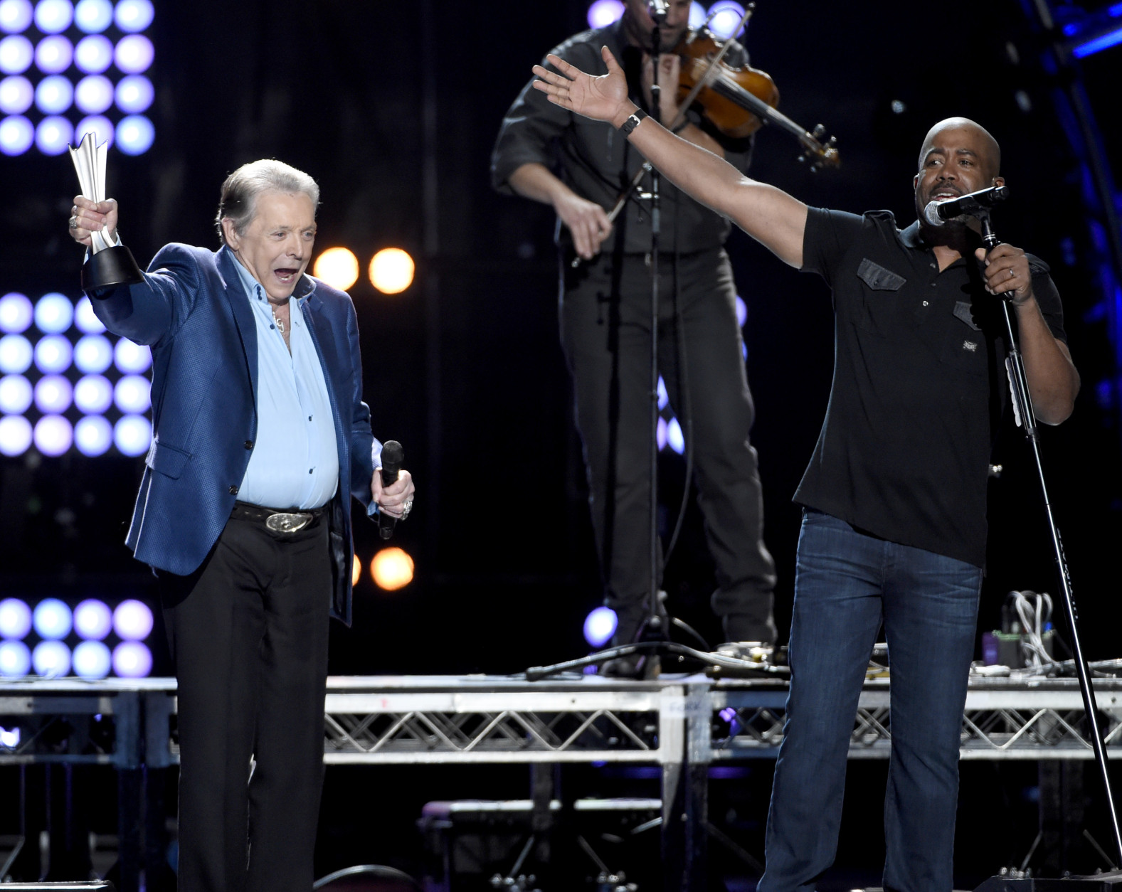 Mickey Gilley accepts the triple crown award at ACM Presents Superstar Duets at Globe Life Park on Friday, April 17, 2015, in Arlington, Texas. Looking on at right is Darius Rucker. (Photo by Chris Pizzello/Invision/AP)