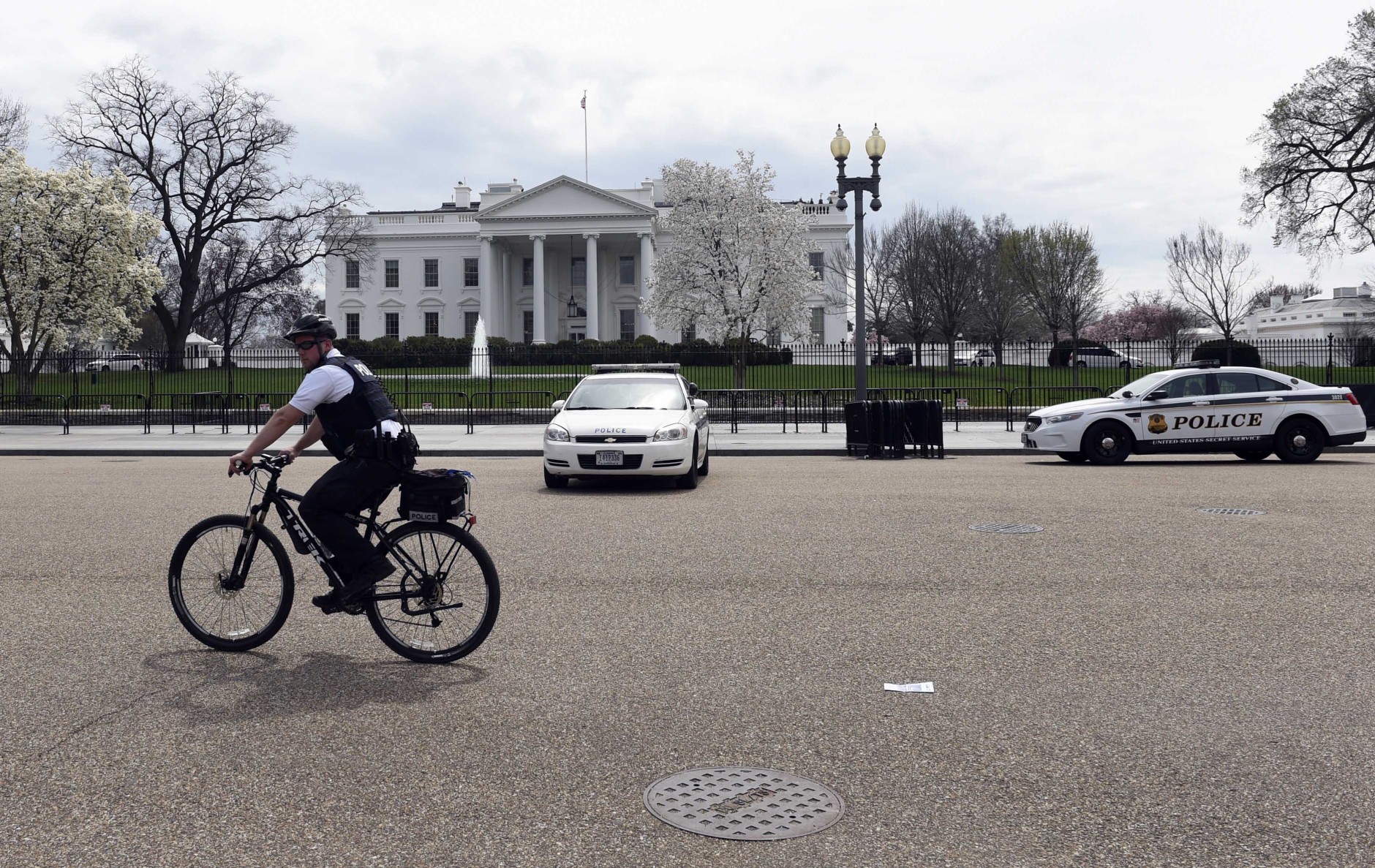 A Secret Service rides his bike on Pennsylvania Avenue outside the White House in Washington, Tuesday, April 7, 2015. The White House, State Department, and Capitol were all affected by reports of widespread power outages across Washington and its suburbs Tuesday afternoon.  (AP Photo/Susan Walsh)