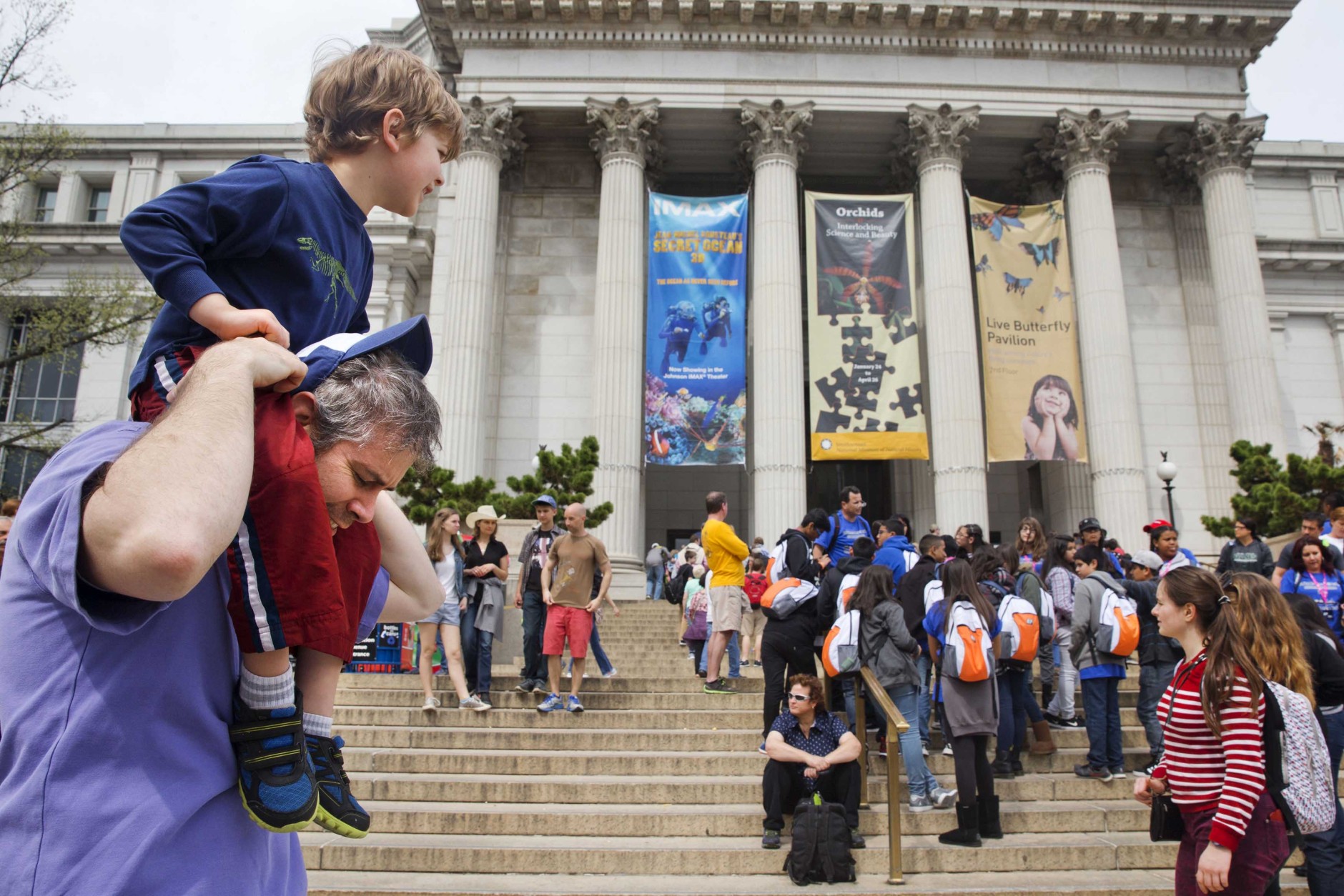 Chris Cellini of Charlotte, N.C., left, lifts his son Aiden Cellini, 5, onto his shoulders after a visit to the Natural History Museum on the National Mall in Washington, Tuesday, April 7, 2015. Widespread power outages affected the White House, State Department, Capitol and other sites across Washington and its suburbs Tuesday afternoon — all because of an explosion at a power plant in southern Maryland, an official said. (AP Photo/Jacquelyn Martin)