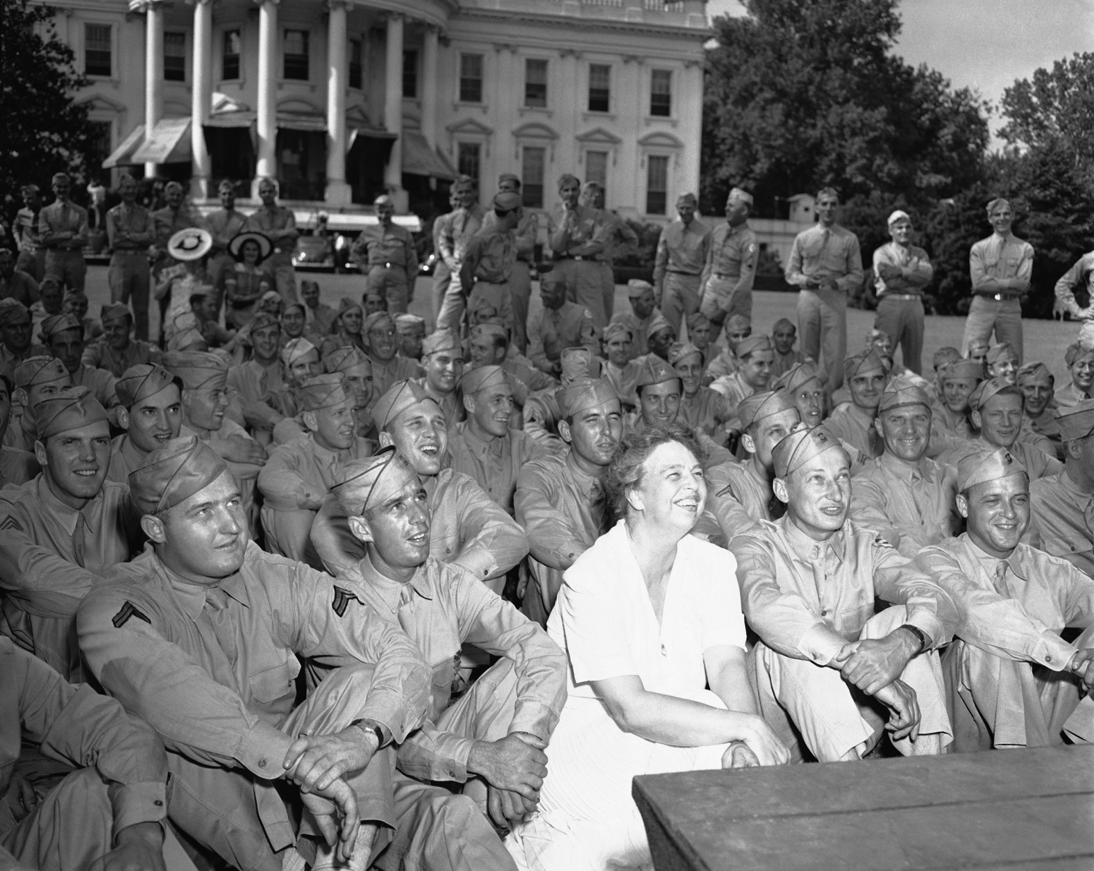 Mrs. Eleanor Roosevelt joined her guests  as she entertained at a Garden Party on June 12, 1942  in Washington at the south lawn of the White House for the over 400 soldiers detailed to guard the executive mansion. They were watching an entertainer. (AP Photo)