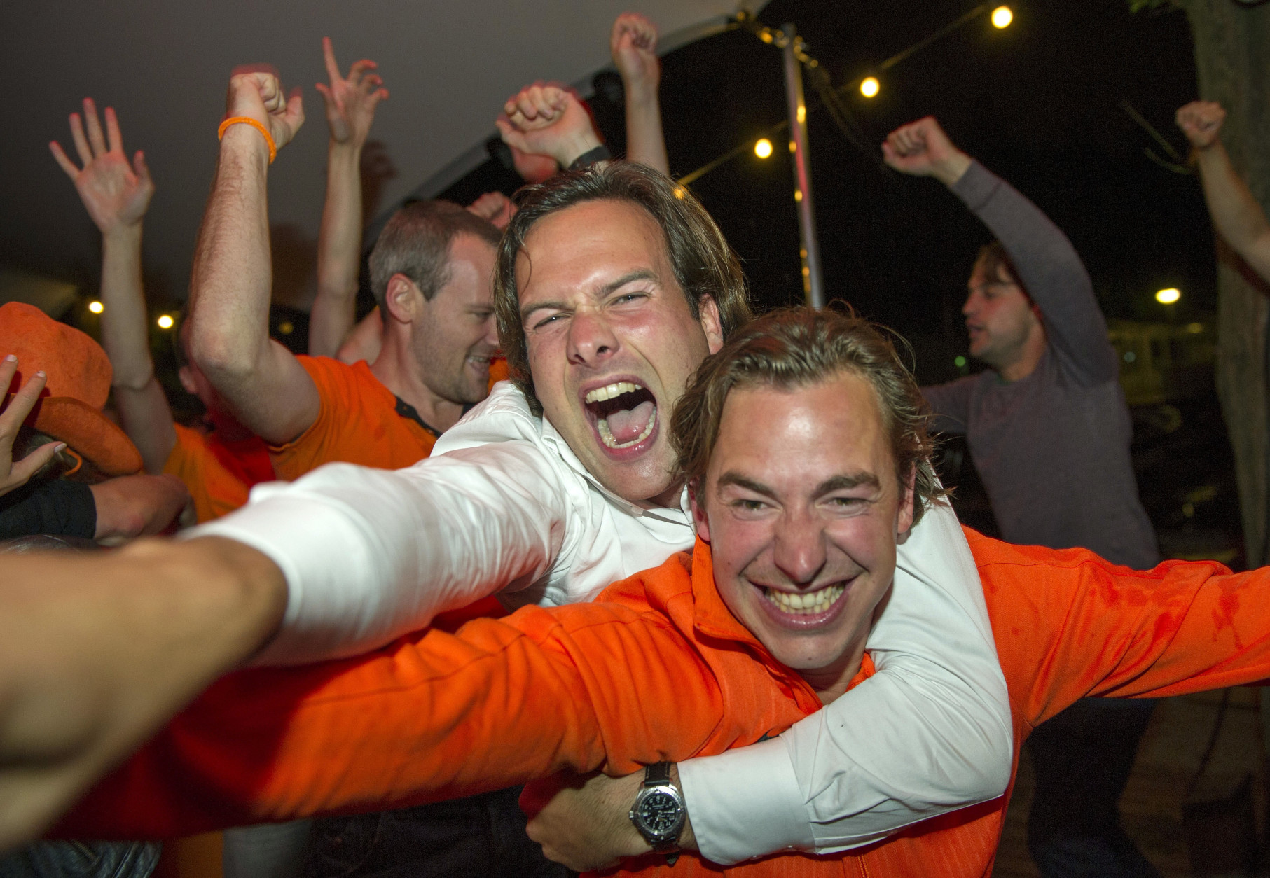 Fans celebrate as they watch the Dutch team win after penalties in the World Cup quarter finals soccer match between the Netherlands and Costa Rica at Strandzuid in Amsterdam, Saturday, July 5, 2014. (AP Photo/Patrick Post)