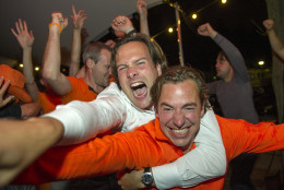 Fans celebrate as they watch the Dutch team win after penalties in the World Cup quarter finals soccer match between the Netherlands and Costa Rica at Strandzuid in Amsterdam, Saturday, July 5, 2014. (AP Photo/Patrick Post)