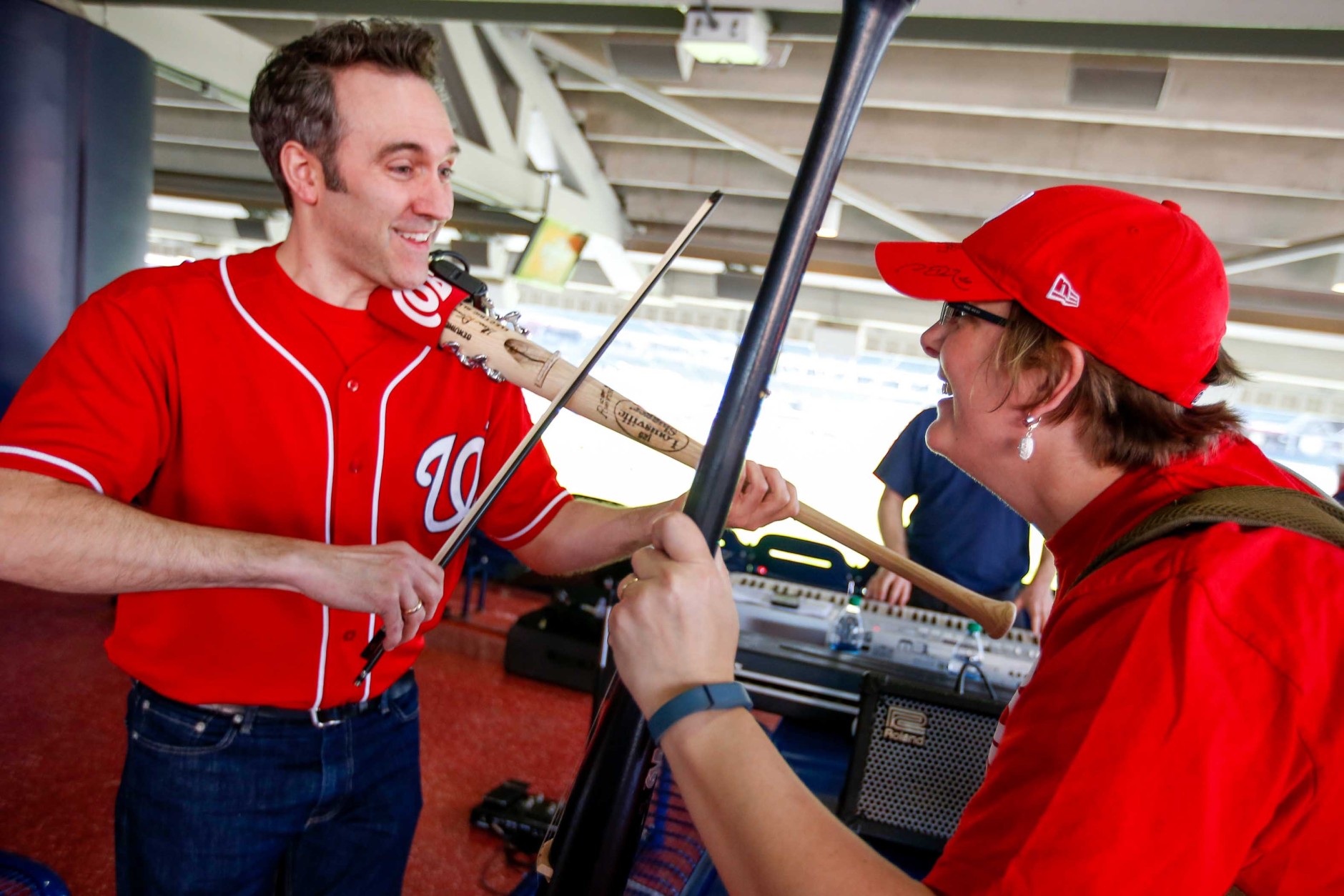 Glenn Donnellan, left, and Anne Marie Karnbach, right, play instruments fashioned out of baseball bats before a baseball game between the Washington Nationals and the New York Mets on opening day at at Nationals Park, Monday, April 6, 2015, in Washington. (AP Photo/Andrew Harnik)