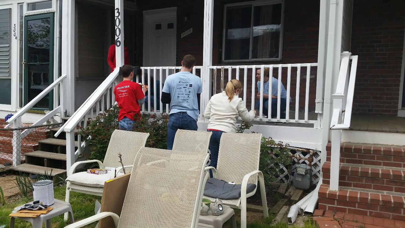 Booz Allen volunteers take time to paint on Rebuilding Together day. (WTOP/Kathy Stewart)