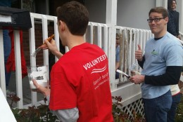 Here, Booz Allen volunteers paint during the Rebuilding Together day. (WTOP/Kathy Stewart)