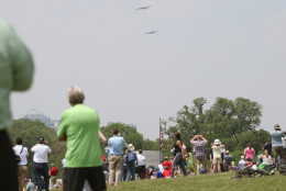 WASHINGTON, DC - MAY 08: People watch as vintage World War II war planes fly down the National Mall May 8, 2015 in Washington, DC. Fifty six vintage war planes took part in a flyover near the WWII memorial for the 70th anniversary Victory in Europe celebration. (Photo by Mark Wilson/Getty Images)