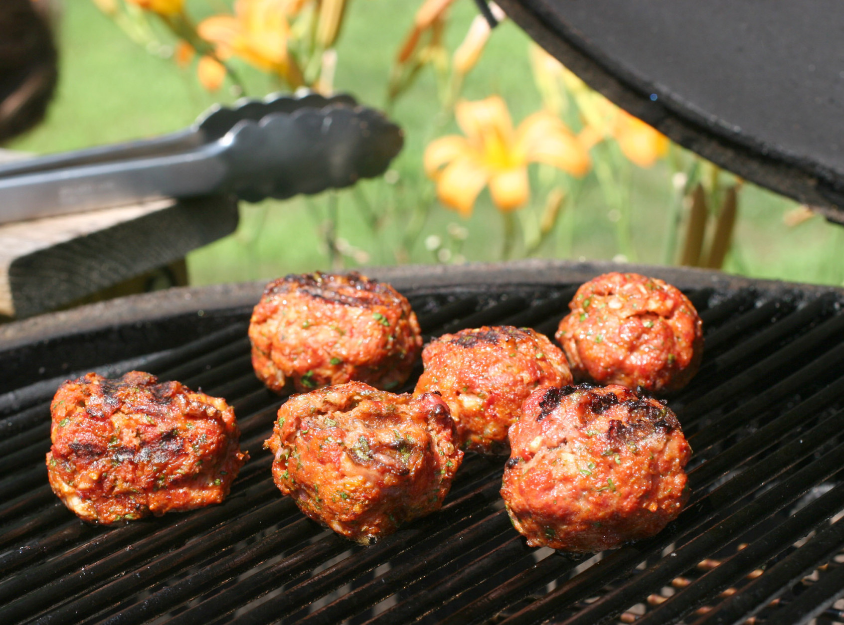 ** FOR USE WITH AP WEEKLY FEATURES **   Grilled Meatballs may sound like an odd idea, but this quick recipe has distinct tomato and savory notes and produces meatballs with tons of flavor that can be cooked entirely on the grill. For a great sandwich, toss slices of provolone cheese over them during the final minute of grilling. (AP Photo/Larry Crowe)