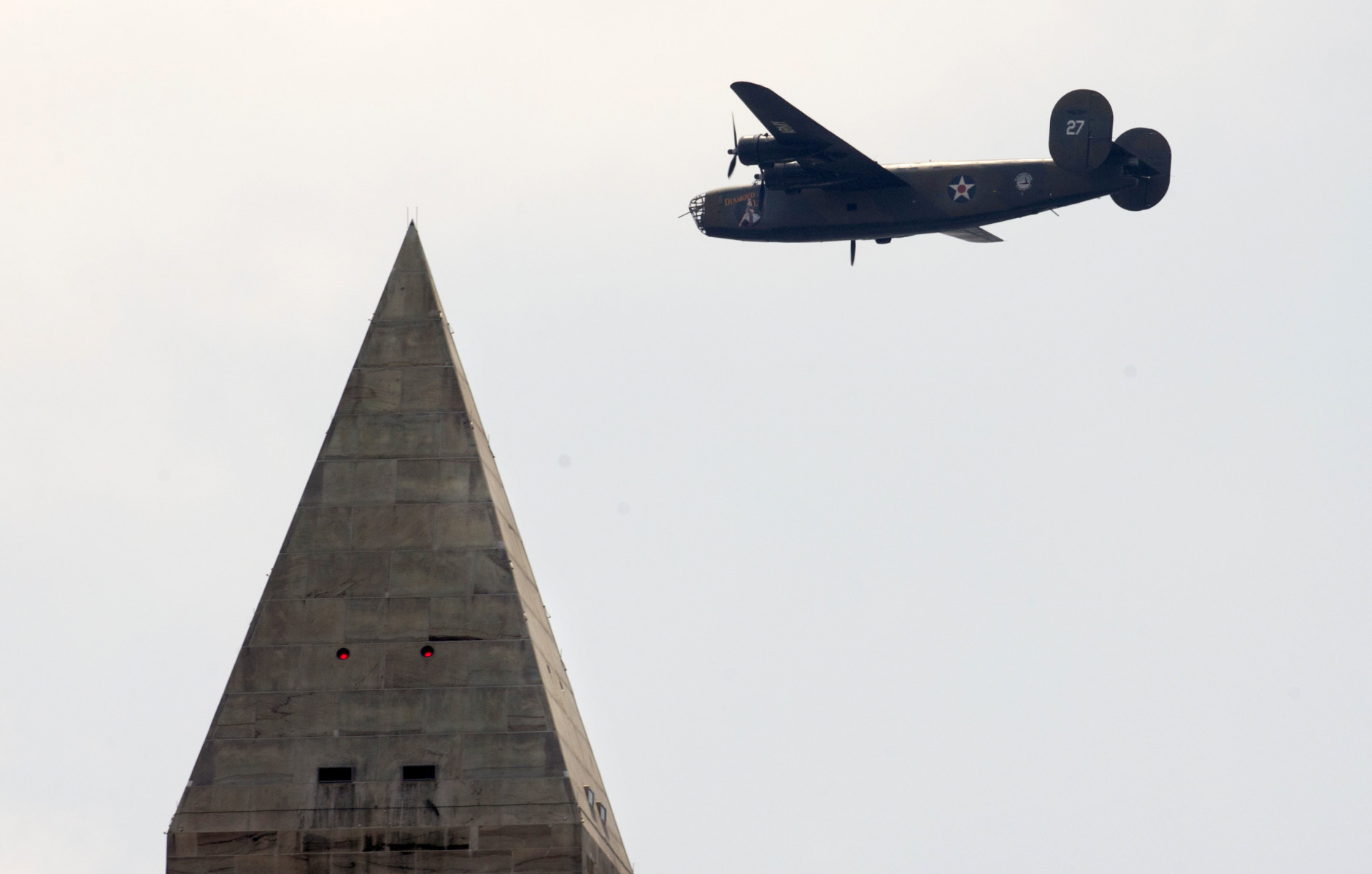 A B-24 Liberator vintage military aircraft from World War II, is seen from the South Lawn of the White House in Washington, Friday, May 8, 2015, as it flies past the Washington Monument to mark the 70th anniversary of Victory in Europe Day. (AP Photo/Carolyn Kaster)