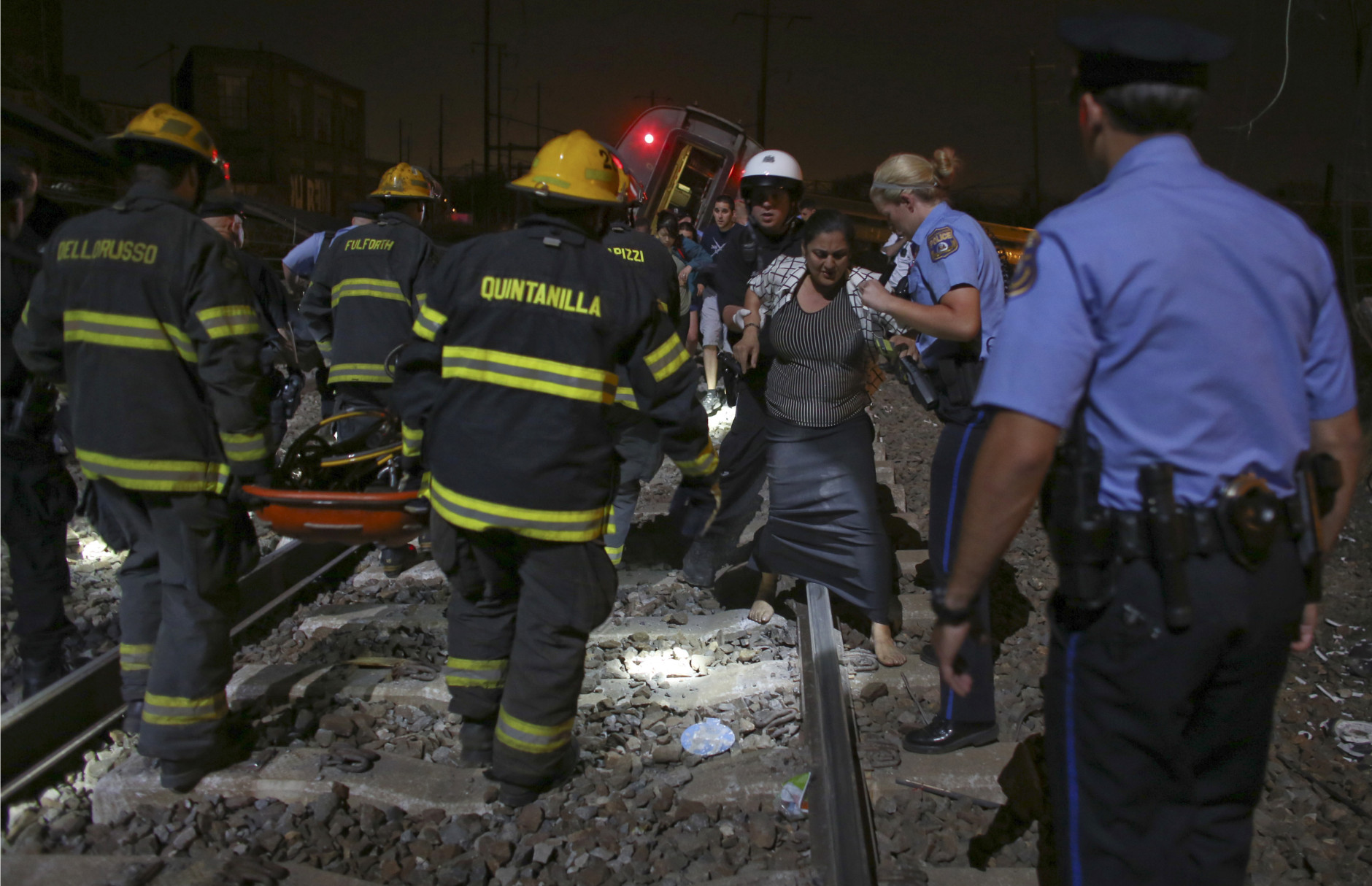 Emergency personnel help passengers at the scene of a train wreck, Tuesday, May 12, 2015, in Philadelphia. An Amtrak train headed to New York City derailed and crashed in Philadelphia. (AP Photo/Joseph Kaczmarek)