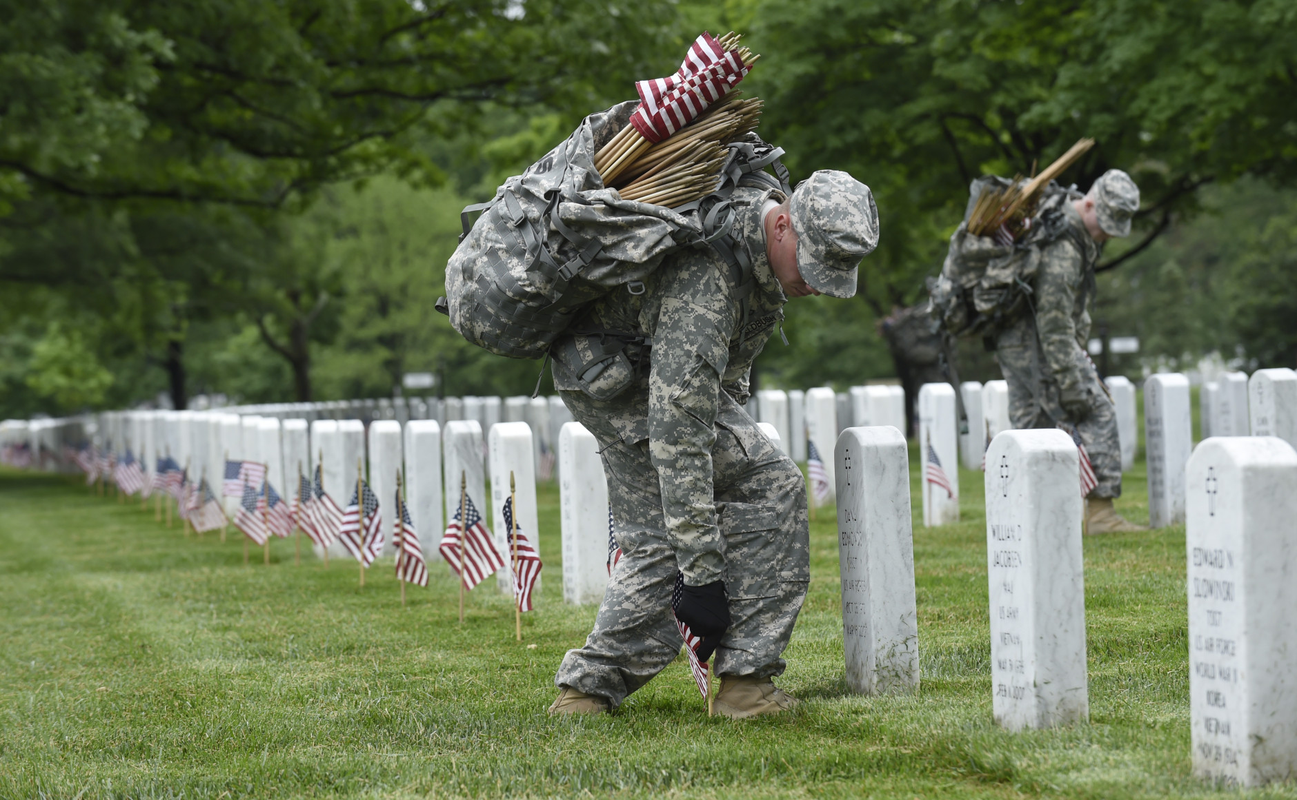Third U.S. Infantry Regiment (The Old Guard) Pfc. Benjamin Feldbush of Stafford County, Va., places a flag in front of a headstone at Arlington National Cemetery in Arlington, Va., Thursday, May 21, 2015. "Flags In" is an annual tradition that is reserved for The Old Guard since its designation as the Armys official ceremonial unit in 1948. They conduct the mission annually at Arlington National Cemetery and the U.S. Soldiers' and Airmen's Home National Cemetery prior to Memorial Day to honor our nations fallen military heroes. (AP Photo/Susan Walsh)