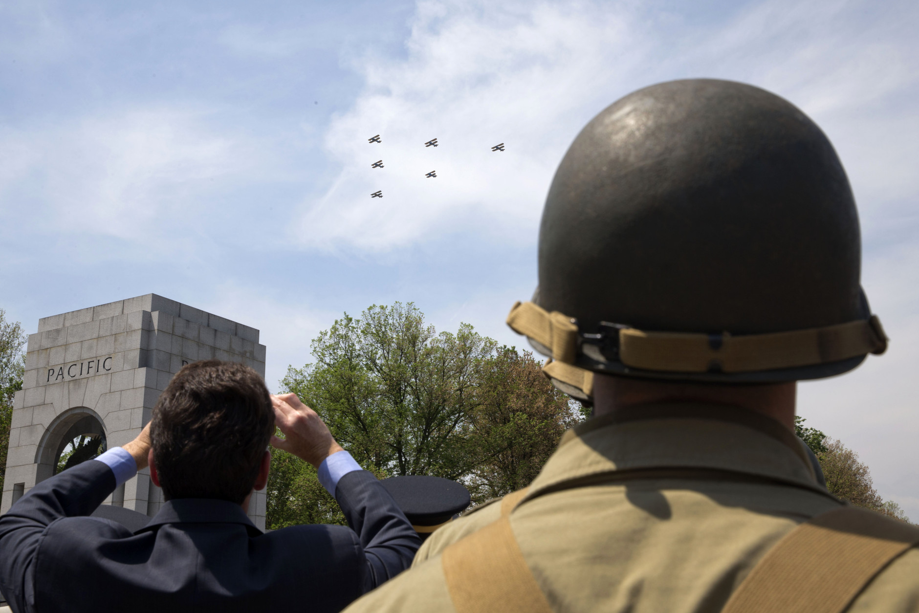 A soldier with the 3rd U.S. Infantry wears a World War II era uniform as he watches as World War II aircraft fly over the World War II Memorial in Washington, Friday, May 8,2015, on the 70th anniversary of Victory in Europe Day (VE Day). The Flyover above the National Mall features historically sequenced formations of more than 50 vintage World War II aircraft. (AP Photo/Jacquelyn Martin)