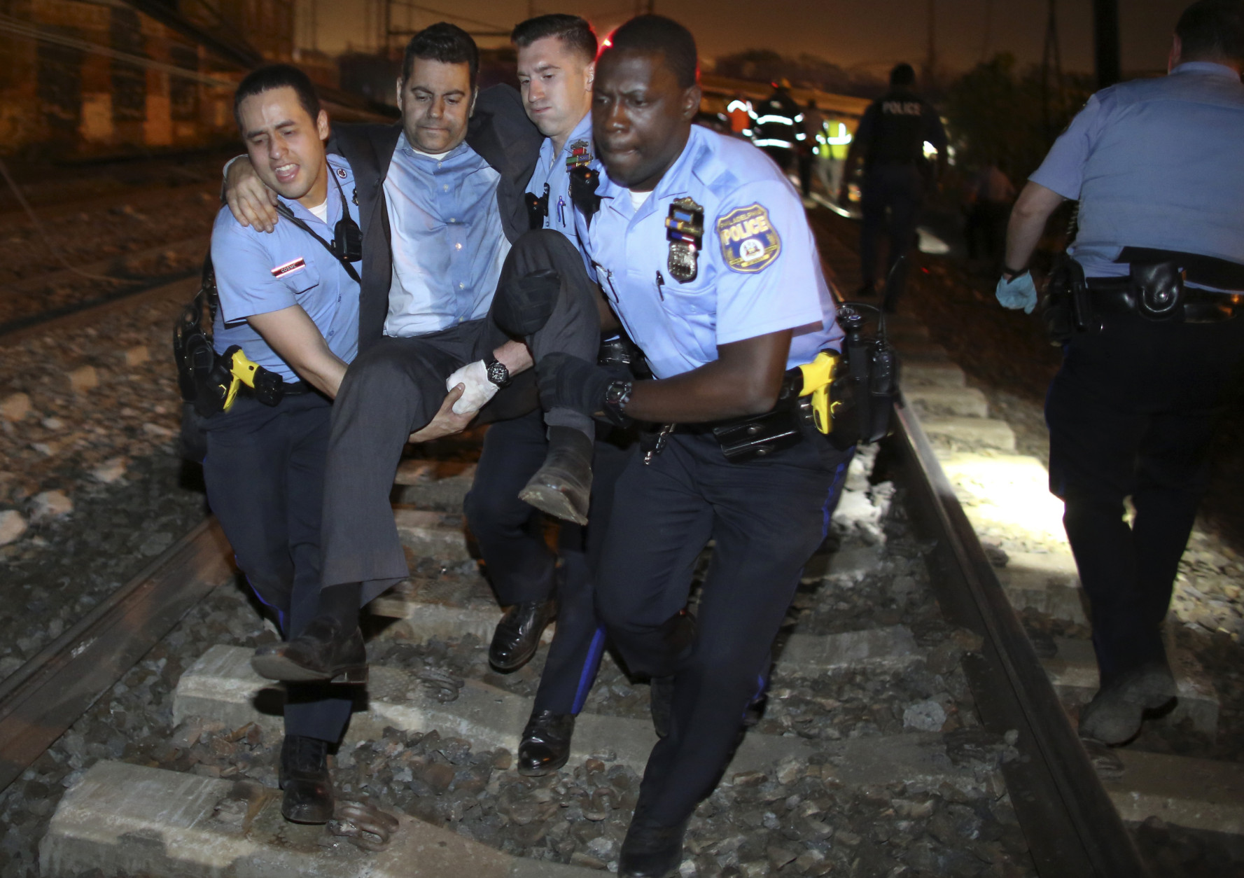 Emergency personnel help a passenger at the scene of a train wreck, Tuesday, May 12, 2015, in Philadelphia. An Amtrak train headed to New York City derailed and crashed in Philadelphia. (AP Photo/Joseph Kaczmarek)
