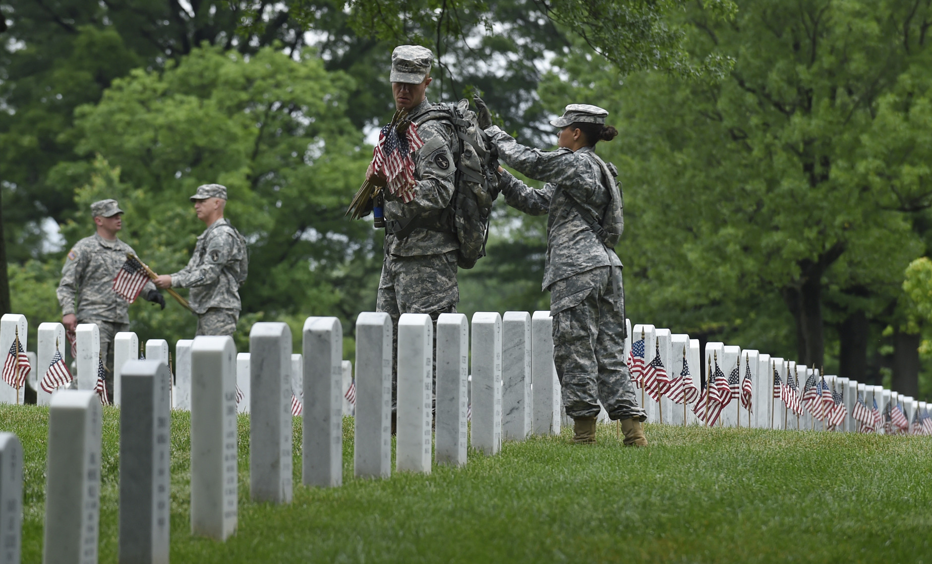 Members of the Old Guard place a flag in front of each headstone at Arlington National Cemetery in Arlington, Va., Thursday, May 21, 2015. Flags-In is a time honored tradition that is reserved for Soldiers of the 3rd U.S. Infantry Regiment (The Old Guard).  Since The Old Guard's designation as the Armys official ceremonial unit in 1948, they have conducted this mission annually at Arlington National Cemetery prior to Memorial Day to honor our nations fallen military heroes. (AP Photo/Susan Walsh)