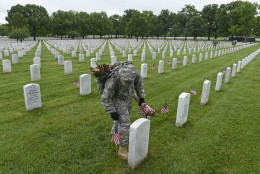 Third U.S. Infantry Regiment (The Old Guard) Pfc. Kaitlyn Bolde of Scotia, N.Y., places a flag in front of a headstone at Arlington National Cemetery in Arlington, Va., Thursday, May 21, 2015."Flags In" is an annual tradition that is reserved for The Old Guard since its designation as the Armys official ceremonial unit in 1948. They conduct the mission annually at Arlington National Cemetery and the U.S. Soldiers' and Airmen's Home National Cemetery prior to Memorial Day to honor the nations fallen military heroes. (AP Photo/Susan Walsh)