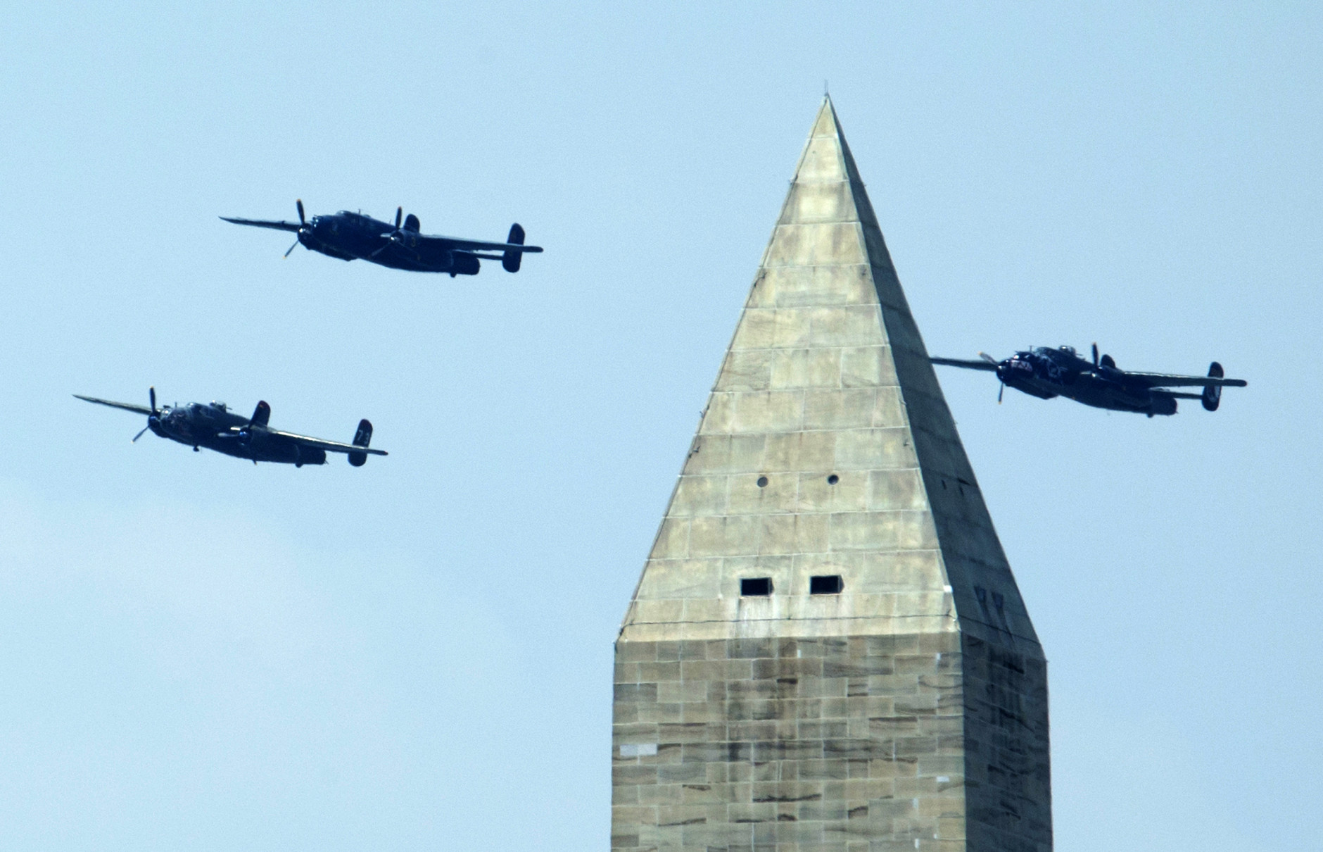 The North American B-25 Mitchell bombers fly in the Doolittle Raid formation during a flyover near the Washington Monument, Friday, May 8, 2015, over Washington. The World War II vintage aircraft were marking the 70th anniversary of the end of the war in Europe on May 8, 1945, and commemorating the Allied victory in Europe during World War II. (AP Photo/Manuel Balce Ceneta)