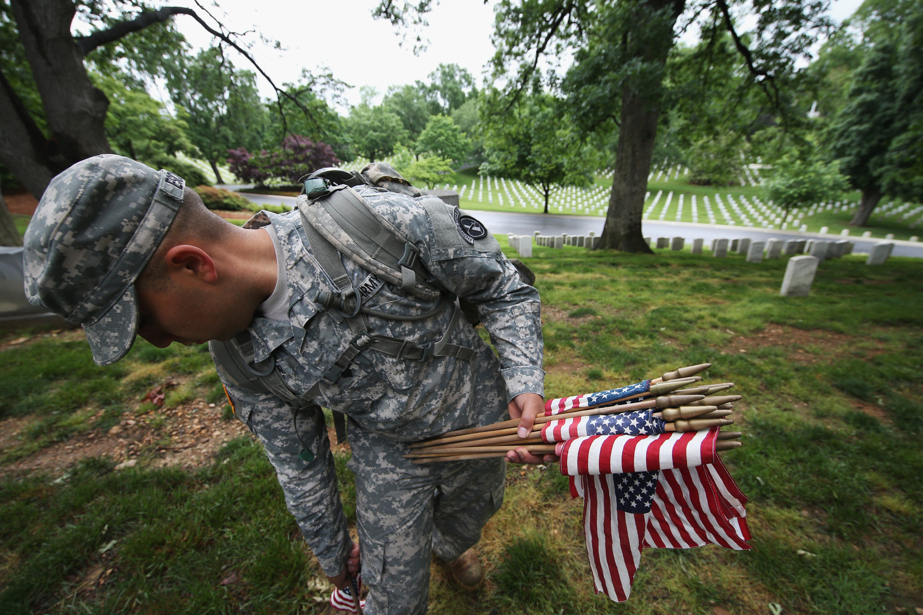 ARLINGTON, VA - MAY 21:  Members of the 3rd U.S. Infantry Regiment place American flags at the graves of U.S. soldiers buried at Arlington National Cemetery, in preparation for Memorial Day May 21, 2015 in Arlington, Virginia. 'Flags-In' has become an annual ceremony since the 3rd U.S. Infantry Regiment (The Old Guard) was designated to be an Army's official ceremonial unit in 1948.  (Photo by Win McNamee/Getty Images)