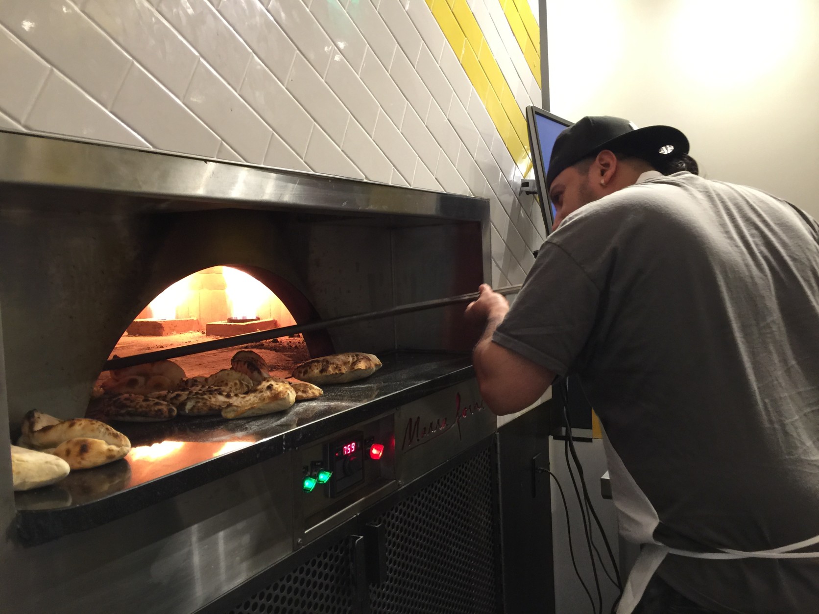 Daniel Salamanca gets to work at the oven at Veloce. (WTOP/Kristi King)