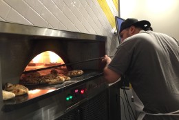 Daniel Salamanca gets to work at the oven at Veloce. (WTOP/Kristi King)