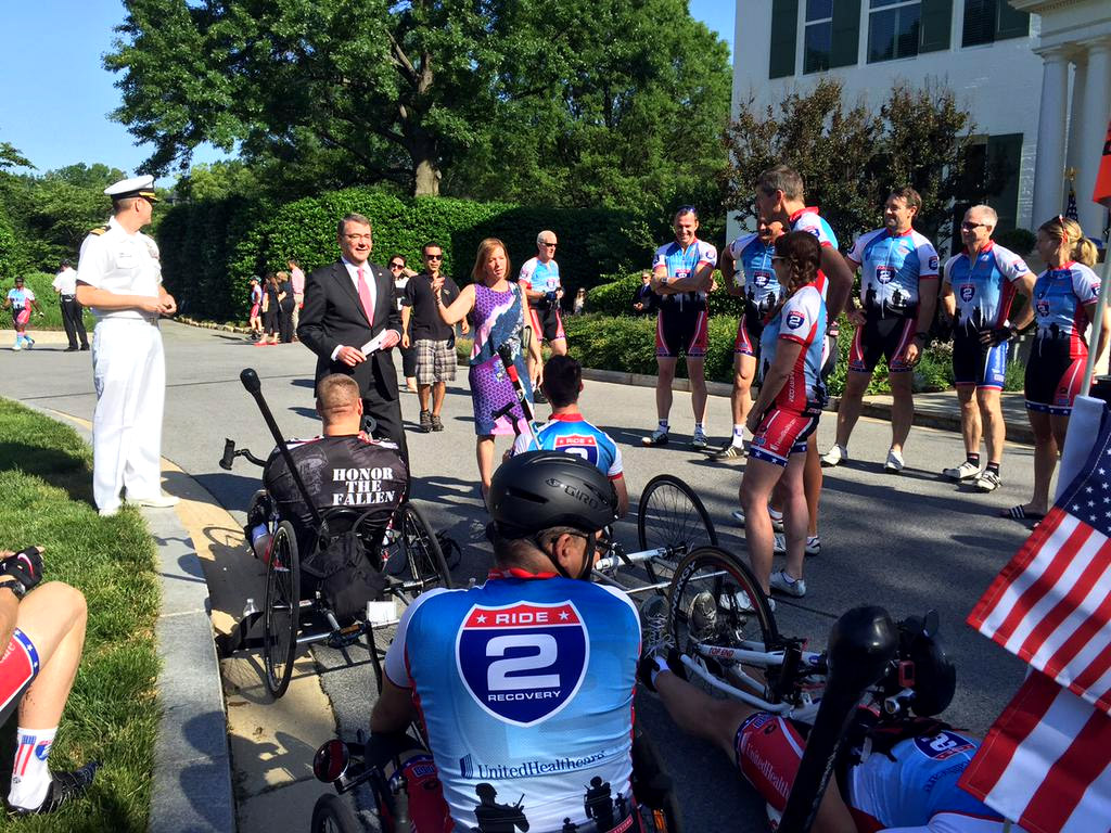 Commander Larry Meehan and Defense Secretary Ash Carter/greet wounded warrior cyclists in front of the vice president's residence Monday Morning. The cyclists will ride from D.C. to Virginia Beach. (WTOP/Kristi King)